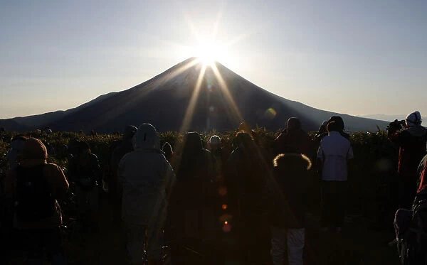 People admire the moment the sun rises just above Mt. Fuji in Fujikawaguchiko