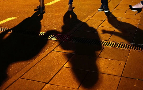 People cast their shadows outside a bar in Moscow, Russia