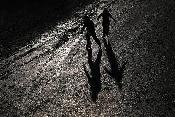 People cast shadows while skating on the Rideau Canal in Ottawa