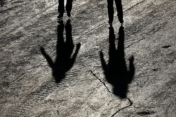 People cast shadows while skating on the Rideau Canal in Ottawa