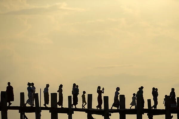 People cross U Bein bridge over Tuangthaman Lake in Mandalay, Myanmar