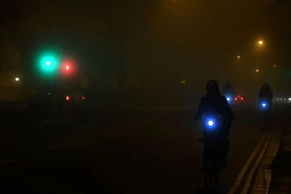 People cycle through heavy fog in Dublin