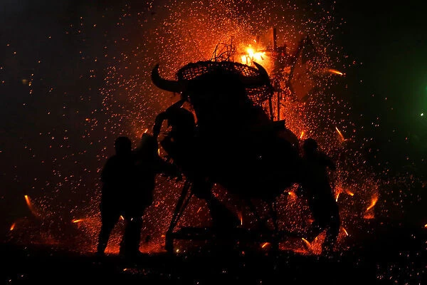 People enjoy fireworks exploding from a traditional bull figure known as El Torito in