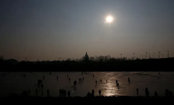 Framed Print : People enjoy a sunny winter day on the frozen New Danube river in Vienna