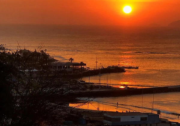 People enjoy the sunset at Pescadores beach in the Chorrillos district of Lima