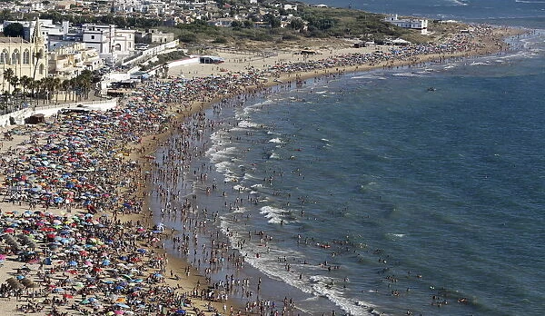 People gather in the Virgen de Regla beach in Chipiona, southern Spain