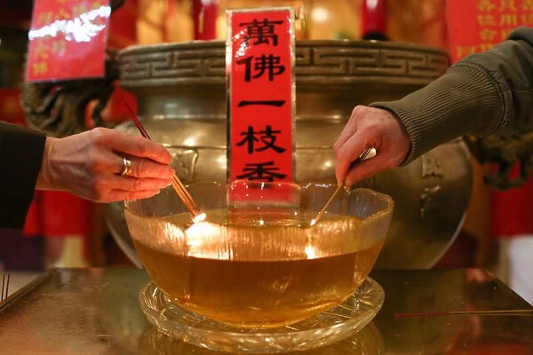 People light incense to bring in the Chinese Lunar New Year of the Dog at Mahayana
