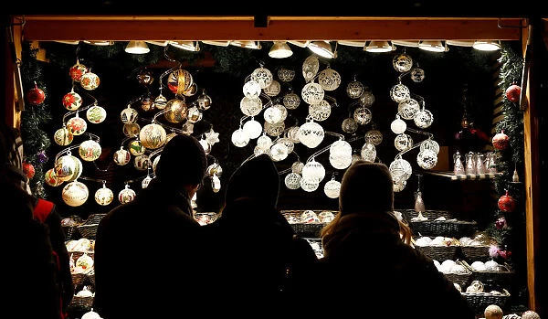 People look at Christmas decorations at a Christmas market in front of the Schoenbrunn