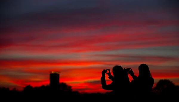 People take pictures of sunset in Berlin