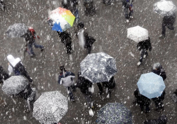 People protect themselves with umbrellas from falling snow in Rome