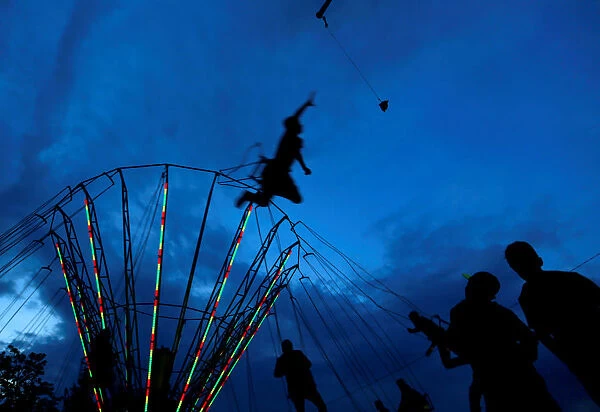 People ride on a swing carousel as part of the traditional celebration of Saint George s