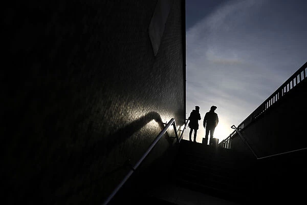 Two people stand at the top of a flight of steps that lead on to London Bridge, in London