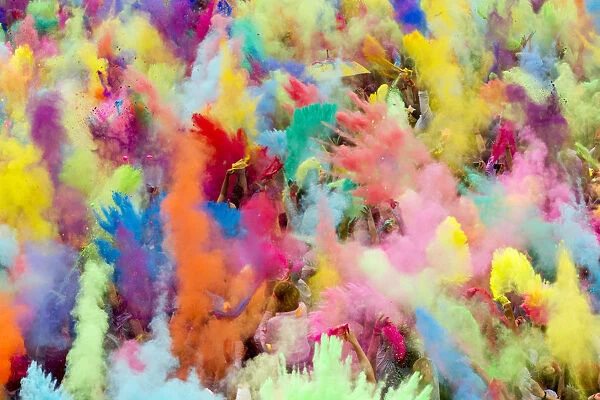 People throw coloured powder in the air during Holi festival celebrations in Berlin