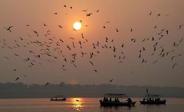 People travel in boats as sun sets for last time in 2008 in Allahabad