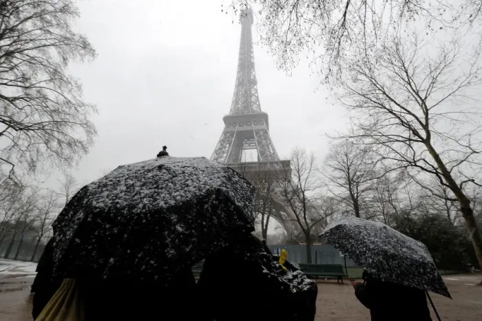 Framed Print : People use umbrellas to take cover from falling snow near the Eiffel Tower in Paris Framed Print : People use umbrellas to take cover from falling snow near the Eiffel Tower in Paris
