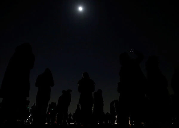 People wait to watch a lunar eclipse at the open air skydeck of Roppongi Hills Tower in