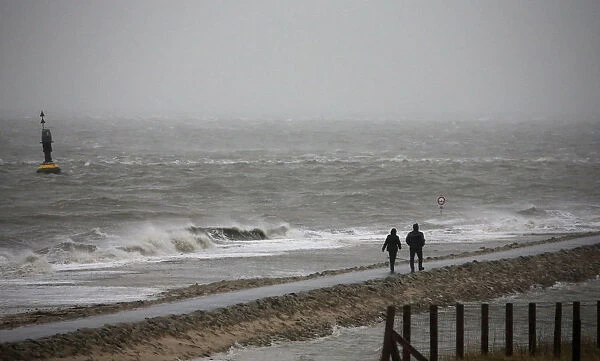People walk on a beach at the North Sea in Cuxhaven