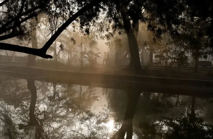 Framed Print : People walk by a lake at a public park on a foggy winter morning in New Delhi Framed Print : People walk by a lake at a public park on a foggy winter morning in New Delhi