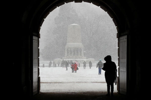 People walk in the snow on Horse Guards Parade in London