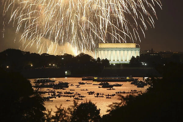 People watch from boats on the Potomac River as Independence Day fireworks light the sky