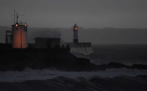 People watch before dawn as large waves and high winds associated with Storm Ffion hit