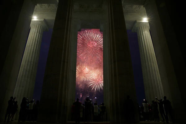 People watch fire works explode at the Lincoln Memorial in celebration of 241st
