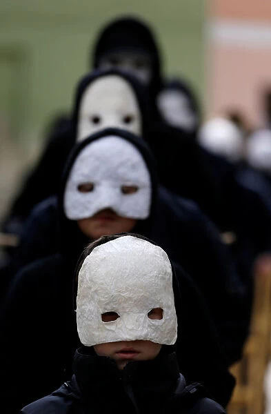 People wearing masks march through the streets during Easter celebrations in Ceske