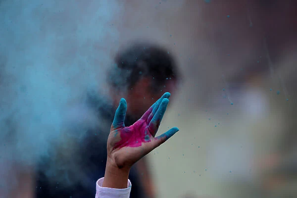 A person throws colored powder during a Holi festival party organized by Jai Jai Hooray