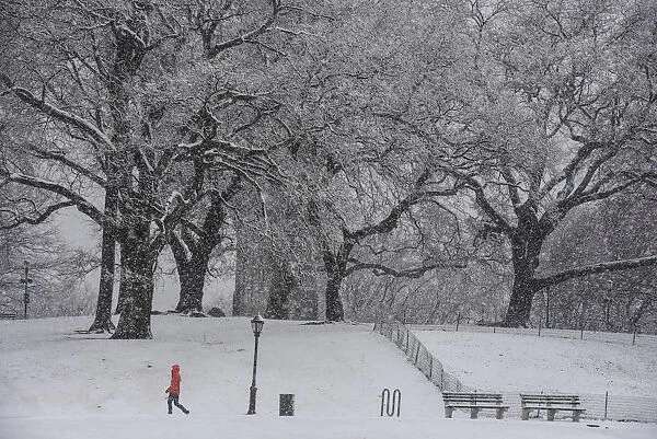 A person walks through the snow during a storm in the Brooklyn borough of New York City