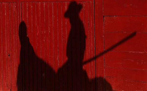 A picador or mounted bullfighter casts his shadow in a barrier during a bullfight