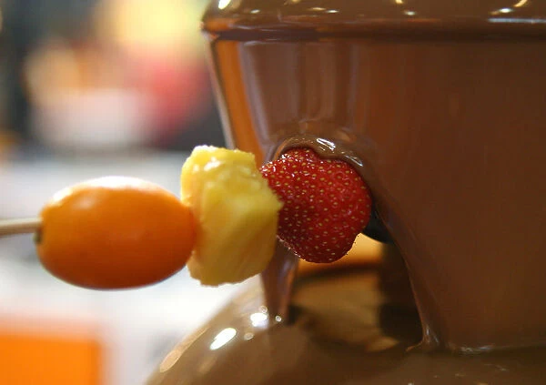 Pieces of fruits are coated with chocolate during the 2nd Chocolate Fair of Barcelona