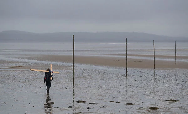 A pilgrim walks accross a tidal causeway on the final leg of the Northern Cross