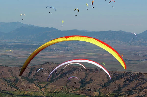 Pilots fly their paragliders during 16th FAI Paragliding World Championship in Krusevo
