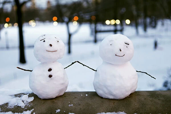Pint-sized snowmen are seen on a railing at Central Park in New York