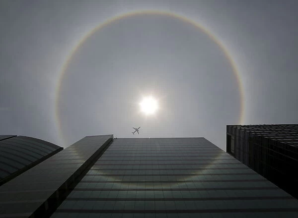 A plane flies past a solar halo in Mexico City