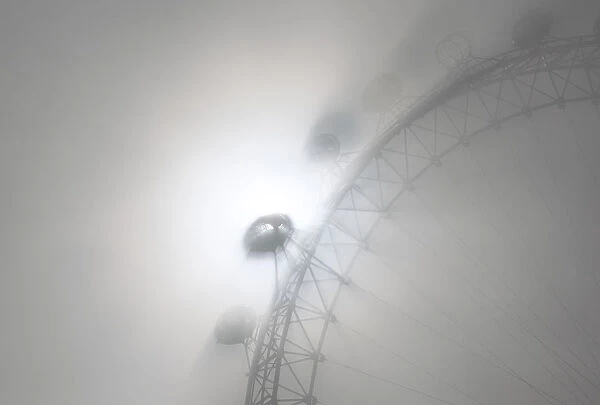 The pods on the London Eye casts shadows against a thick morning fog as the spring
