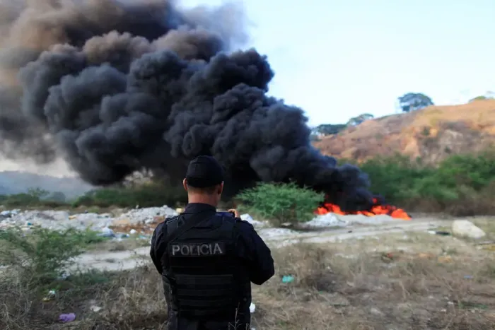 Framed Print : A police officer takes a picture during the incineration of seized cocaine in Ilopango Framed Print : A police officer takes a picture during the incineration of seized cocaine in Ilopango