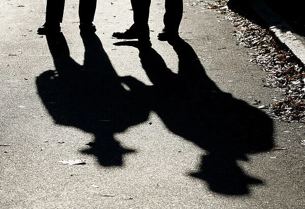 Police officers cast shadows while patrolling outside the U