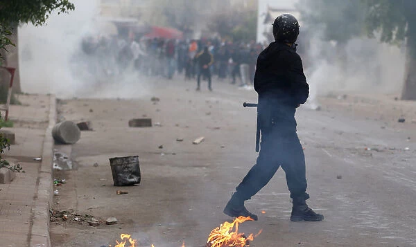Police officers fire tear gas to break up a protest during demonstrations against rising