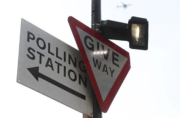 A polling station sign is attached to a lamp post in central London
