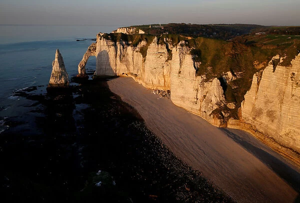 The Porte d Aval, a famous arch of the Etretats cliffs, during sunset, in Etretat