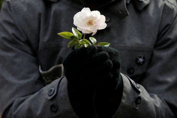 A protester holds a flower during a demonstration to show solidarity with the citizens of