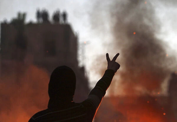 Protester opposing Egyptian President Mursi gestures at riot police during clashes in