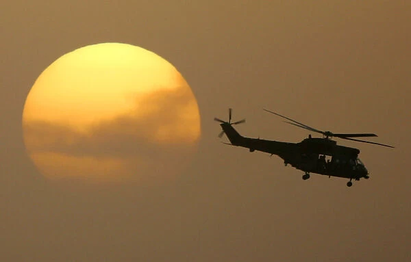 Puma helicopter flies out from the Green Zone at sunset in Baghdad