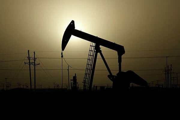 A pump jack operates at sunset in Midland