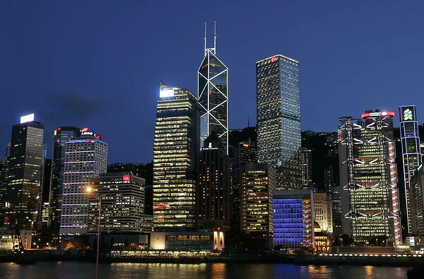Queens Pier is lit up in front of skyline in Hong Kongs central financial district
