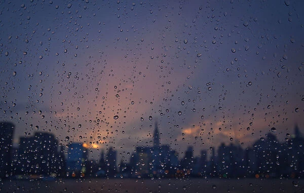 Rain is seen on a window of a ferry boat as it passes midtown Manhattan and the Empire