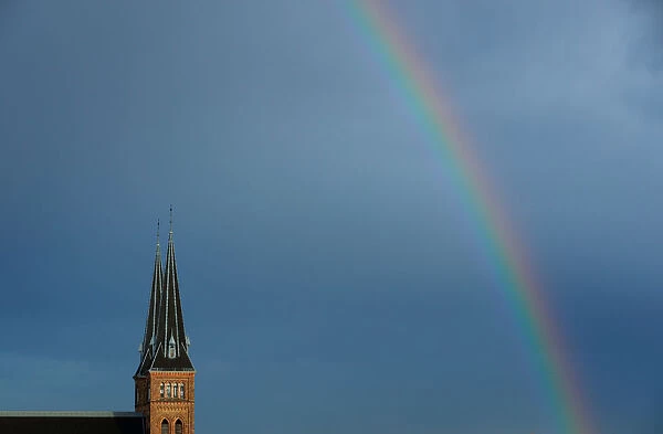 A rainbow appears next to the spires of Familienkirche church in Vienna