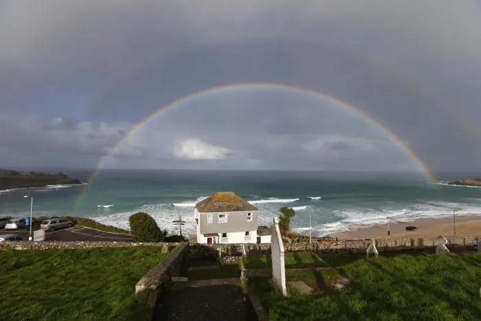 Framed Print : A rainbow forms as a squall moves towards Porthmeor Beach in St Ives in Cornwall Framed Print : A rainbow forms as a squall moves towards Porthmeor Beach in St Ives in Cornwall