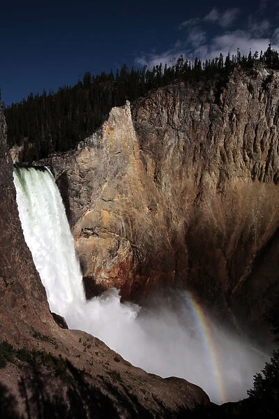A rainbow of light is seen at the base of Yellowstone River Lower Falls in Yellowstone